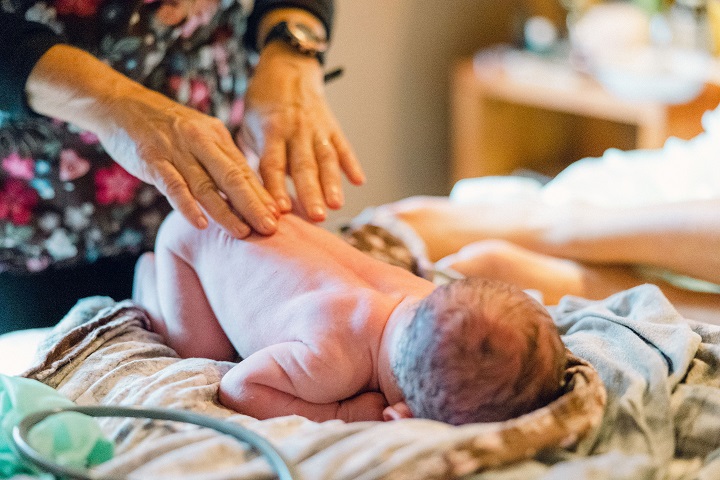 A woman performs a newborn exam